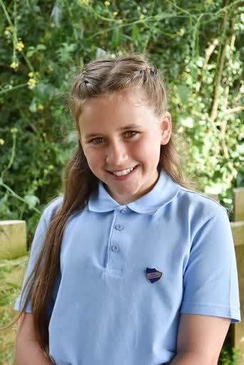 School photo of a smiling girl in a pale blue polo shirt
